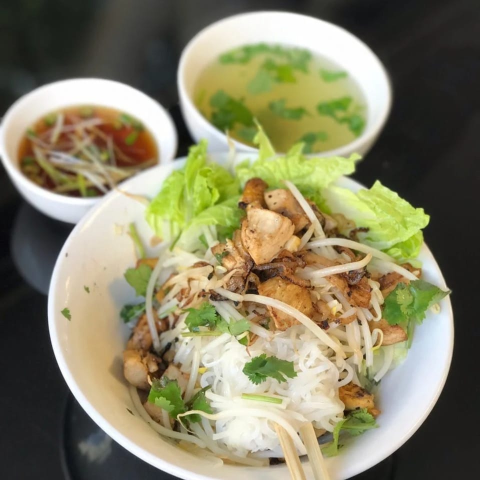 Pho-Chau's vermicelli bowl with grilled chicken, fresh vegetables, and two bowls of broth.